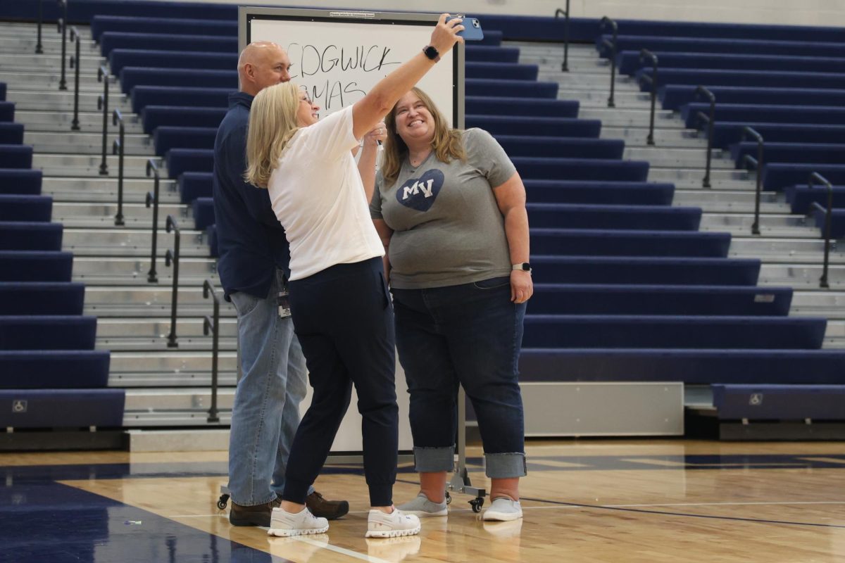 After winning teacher trivia, English teacher Sara Sedgwick, Journalism teacher Kathyrn Habiger and Science teacher Eric Thomas pose for a picture in front of their whiteboard.