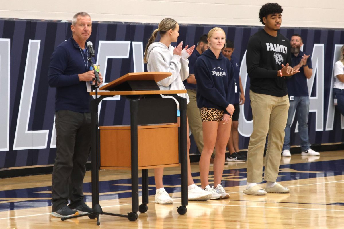 Cross Country Coach Chris McAfee recognizes junior Miley Strathman and seniors Charlotte Caldwell and Jayden Woods for their track state championships.