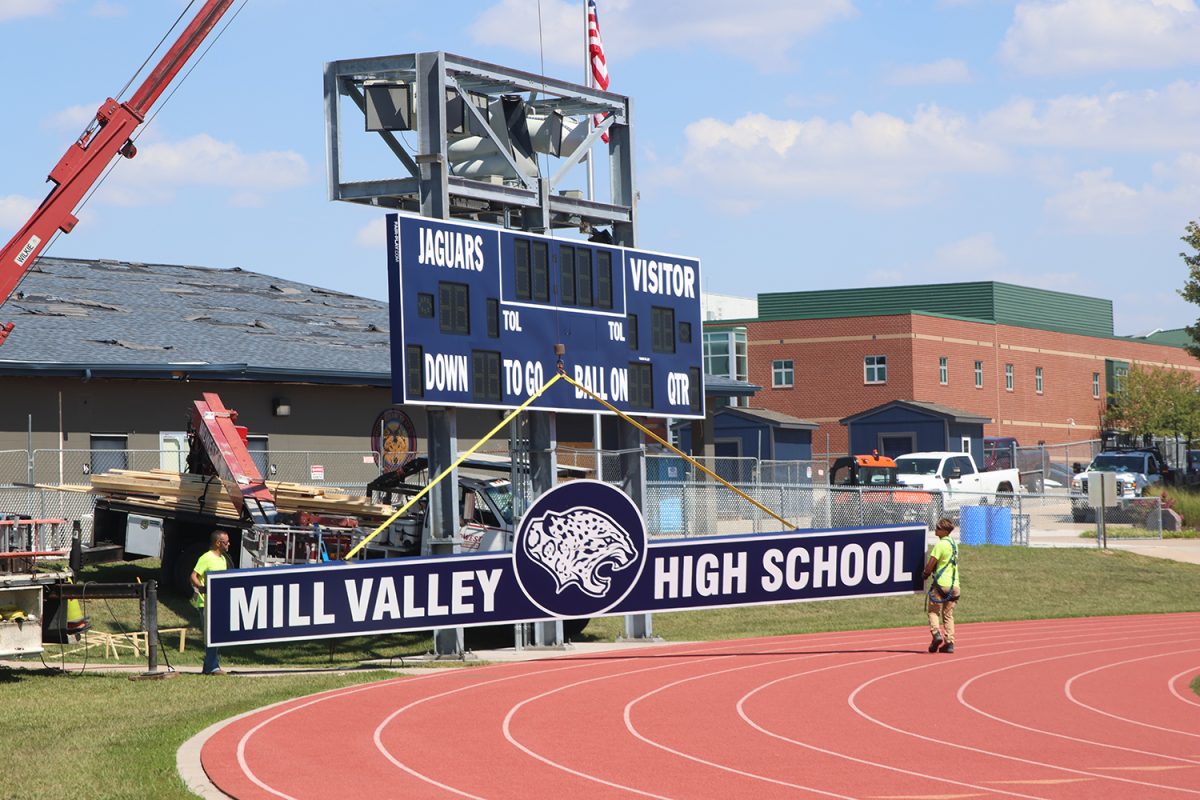 Construction crews uses a crane to lift up a part of the new scoreboard on Sep. 5, 2024 after the previous scoreboard was damaged by a tornado May 20, 2024