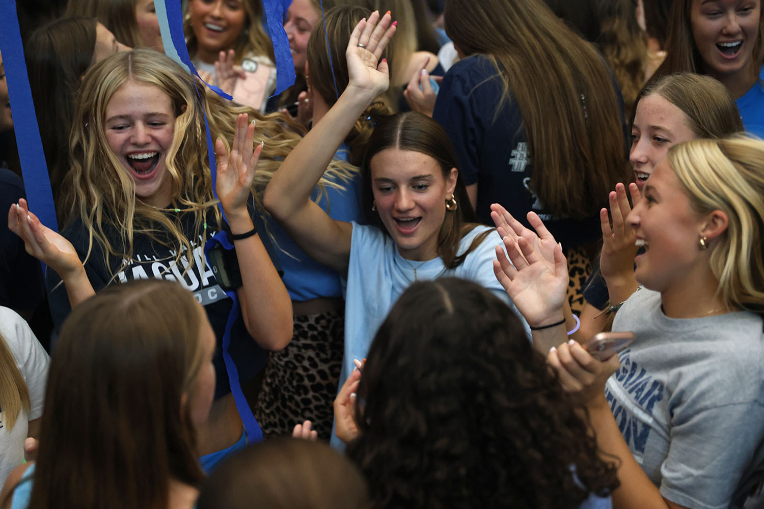 Hands in the air, seniors Calista Marx and Seville Skinner dance to the music with their friends. 