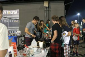 JLC members prepare pancakes for students waiting in line.