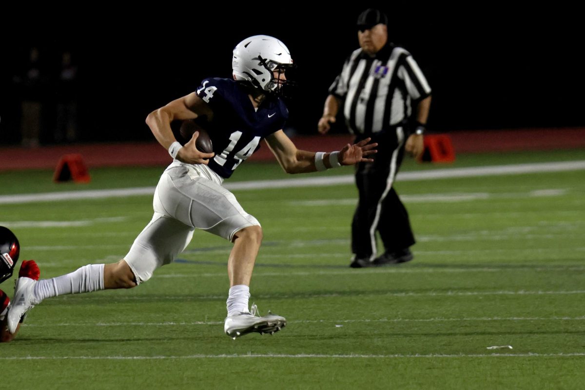 Avoiding the tackle, senior Connor Bohon runs with the ball.