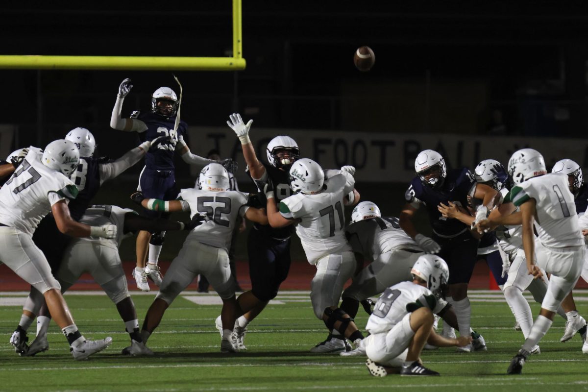 Arms up, senior Braden Peter attempts to block the kick.
