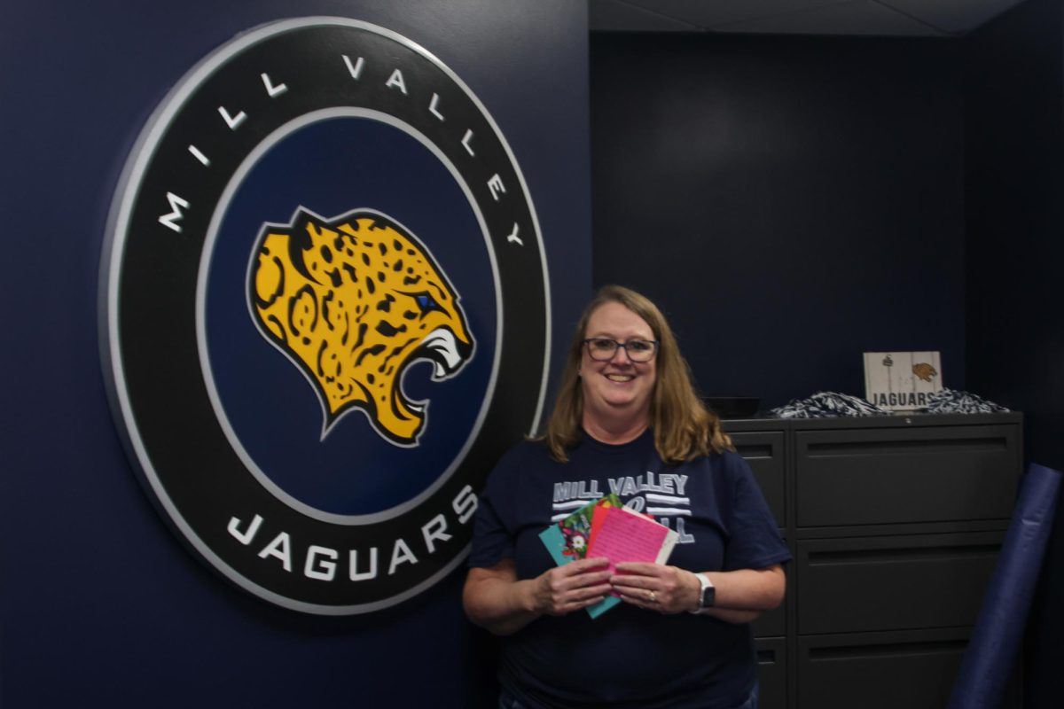 Attendance Secretary Julie Rugenstein holds cards that she received from students.