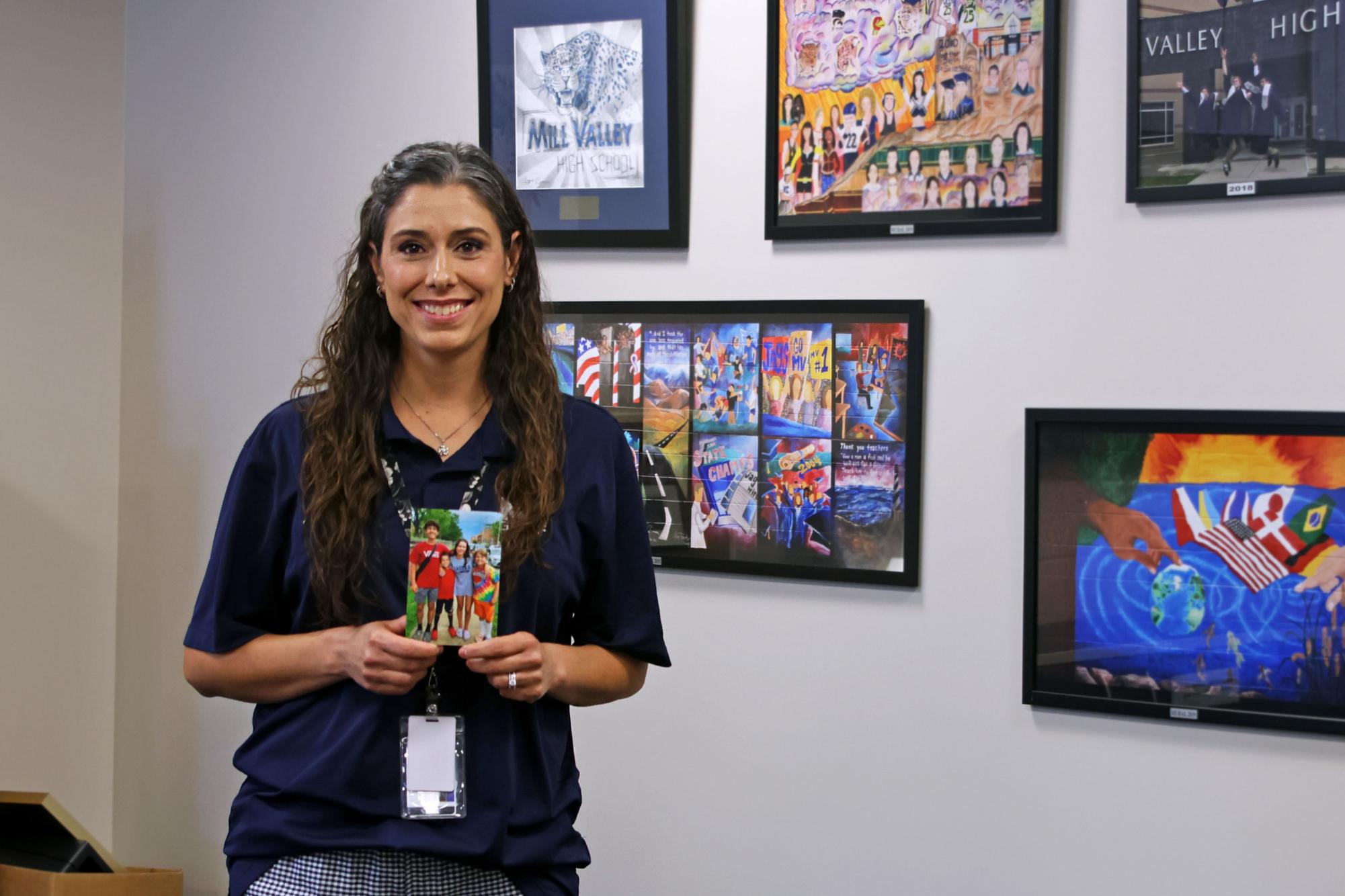 Secretary Leslie Wilson holds a picture of her kids that sits on the side of her computer when she's working. 