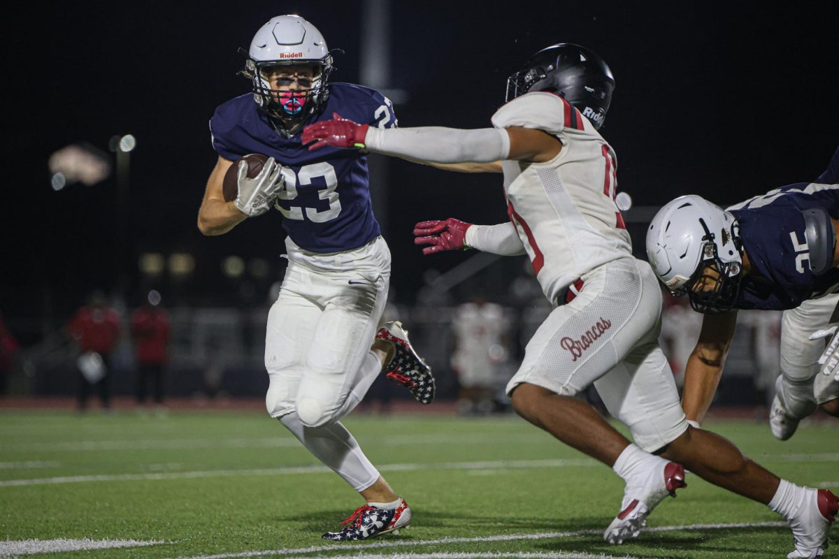 Holding his arm out, senior Grayson Moore stiff arms his opponent.