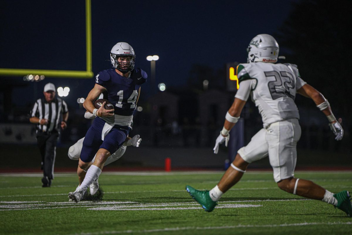 Evading a defender, senior Connor Bohon looks down field at the opposing player.