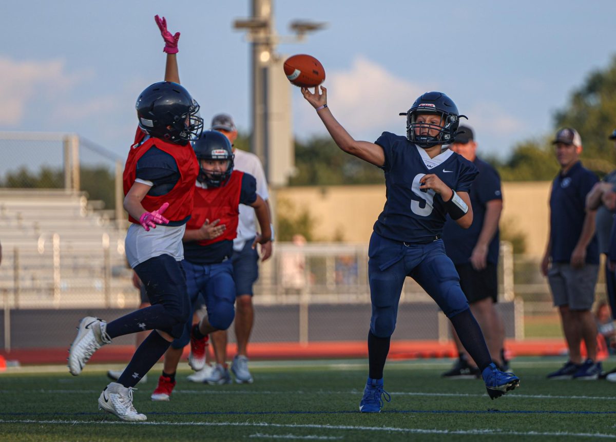 Running out of the pocket, a Junior Jag football player passes the ball.