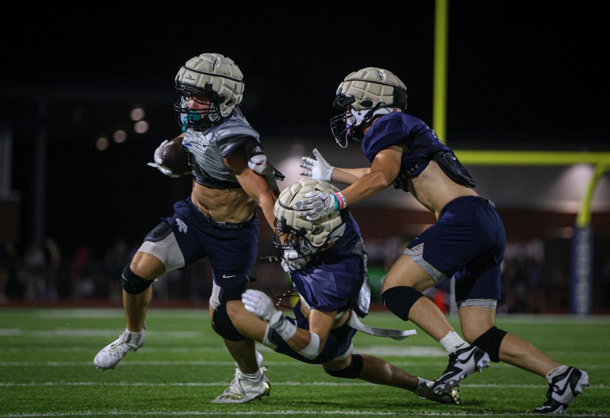 Stiff-arming the defender, senior Andrew Watts fights for extra yards. 