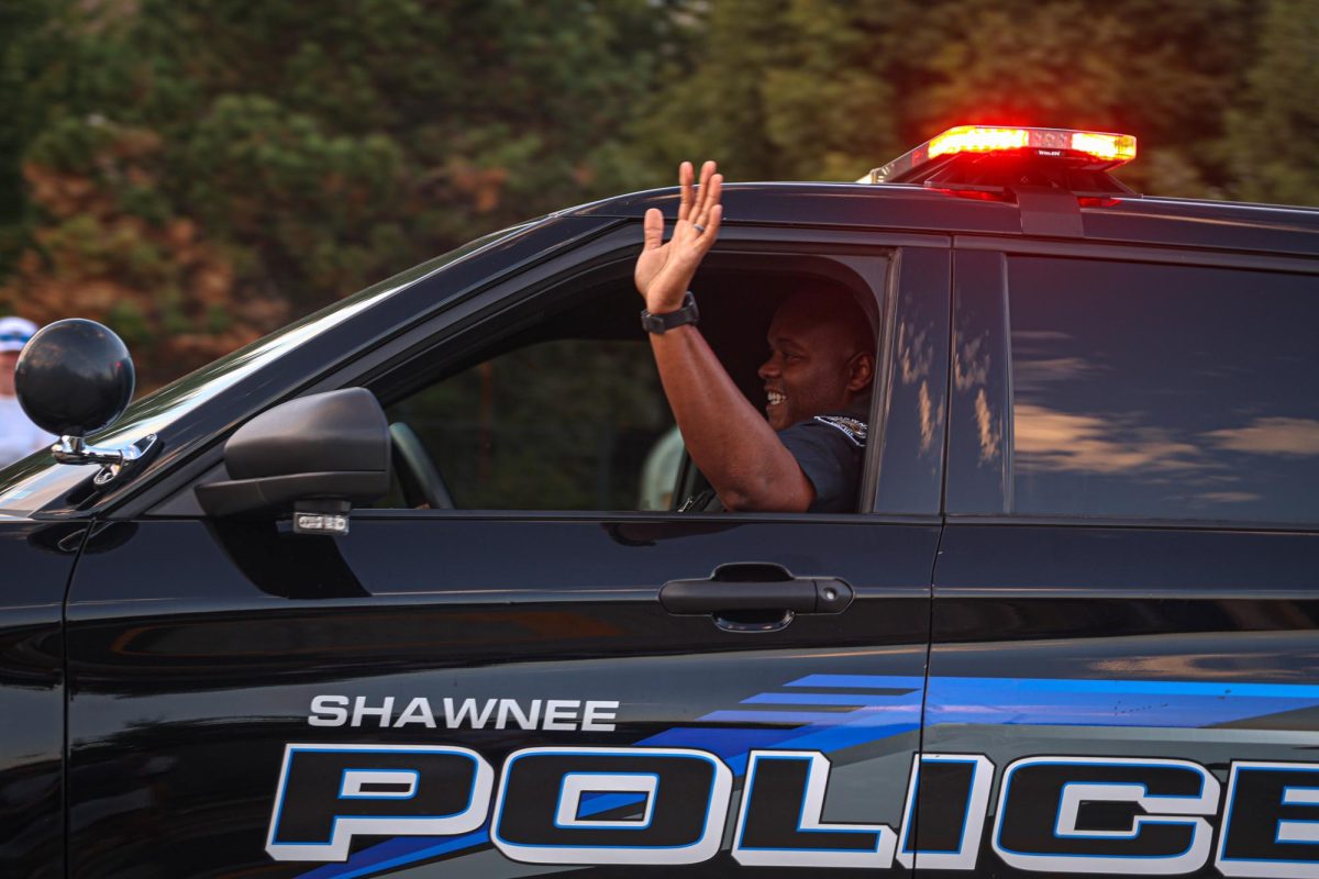 Waving his hand, School Resource Officer Darion Hillman leads the parade.