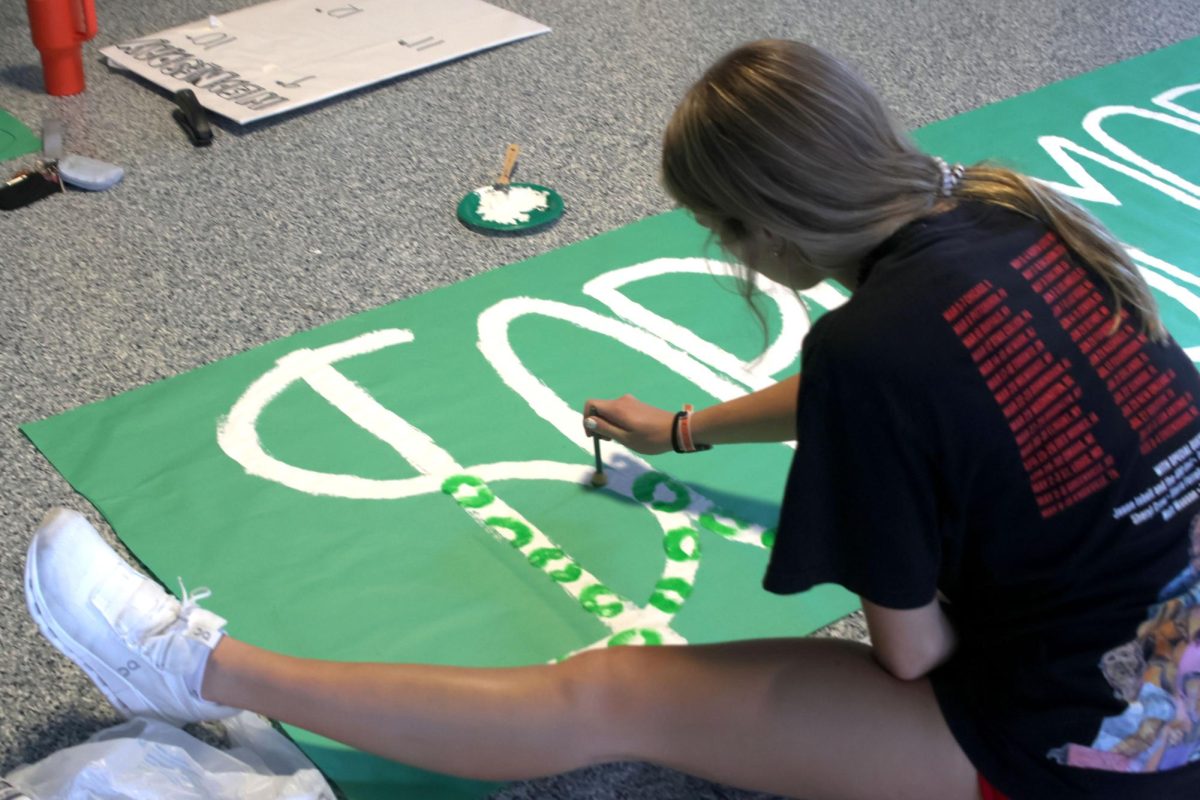 Paintbrush in hand, Sophomore Kenna Long paints “Sophomore” on a poster.

