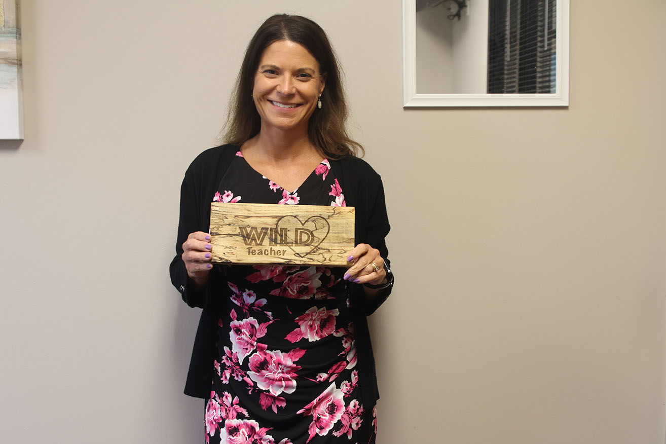 Associate Principal Deb Jaeger holds a "Wild Teacher" sign to remind her that her goal is to help students figure out their future after highschool.