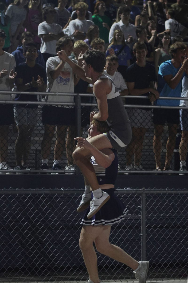 Senior Conner Wood holds senior Thatcher Ivey on his shoulders as they run past the crowd.
