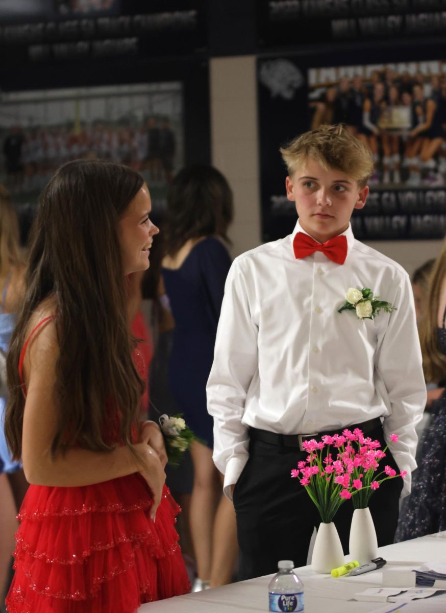 While standing in line, sophomores Ellie Newell and Caden Coup get ready to go to the dance