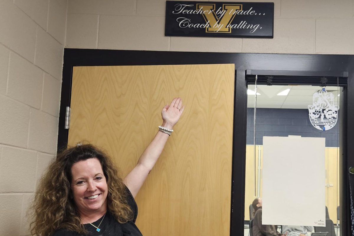 New choir teacher Laura VanLeeuwen poses with a sign given to her by past students. 