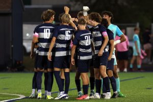 Before the game, the soccer team huddles together.