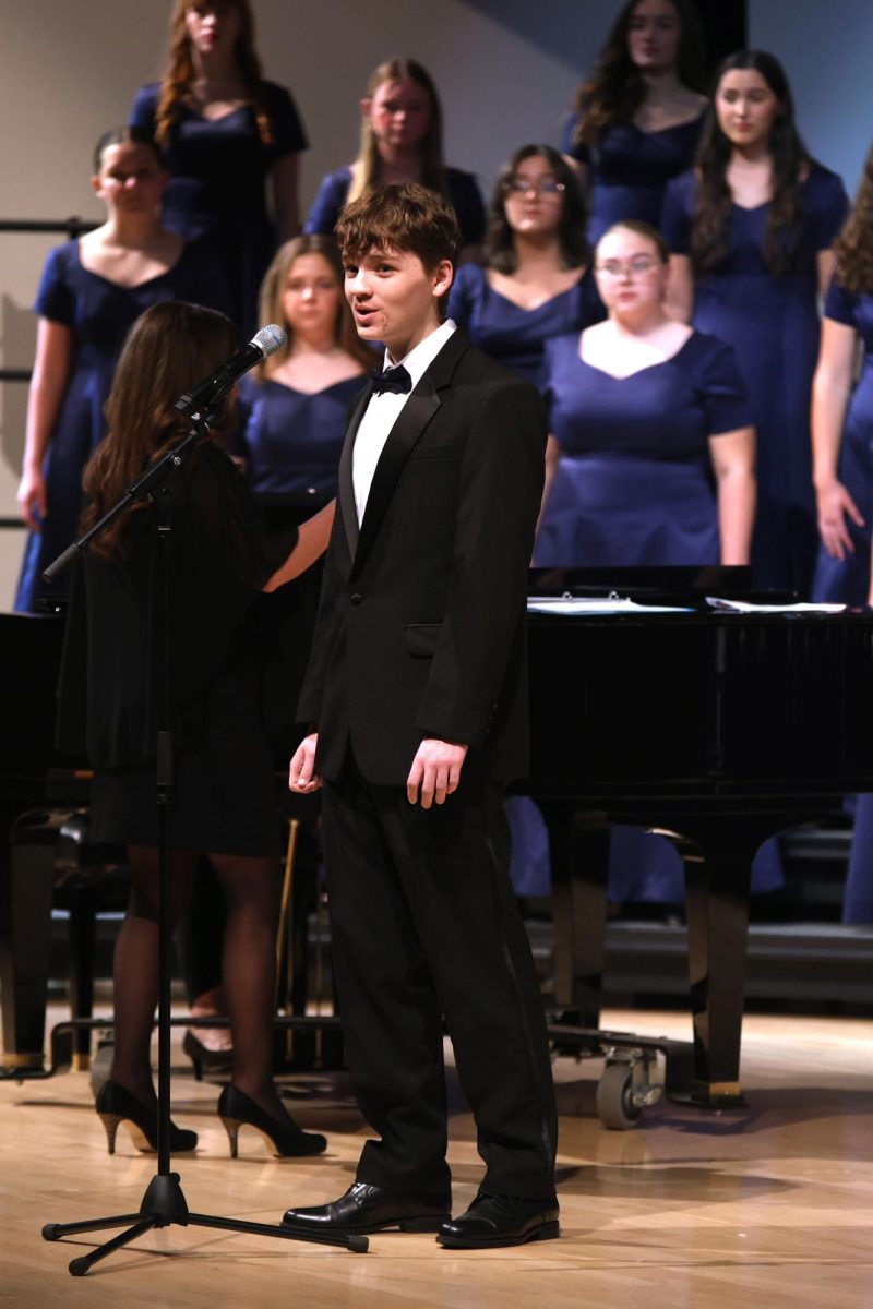 Standing at the microphone, junior Harrison Guest performs a solo during “Runnin’ Home to You”.