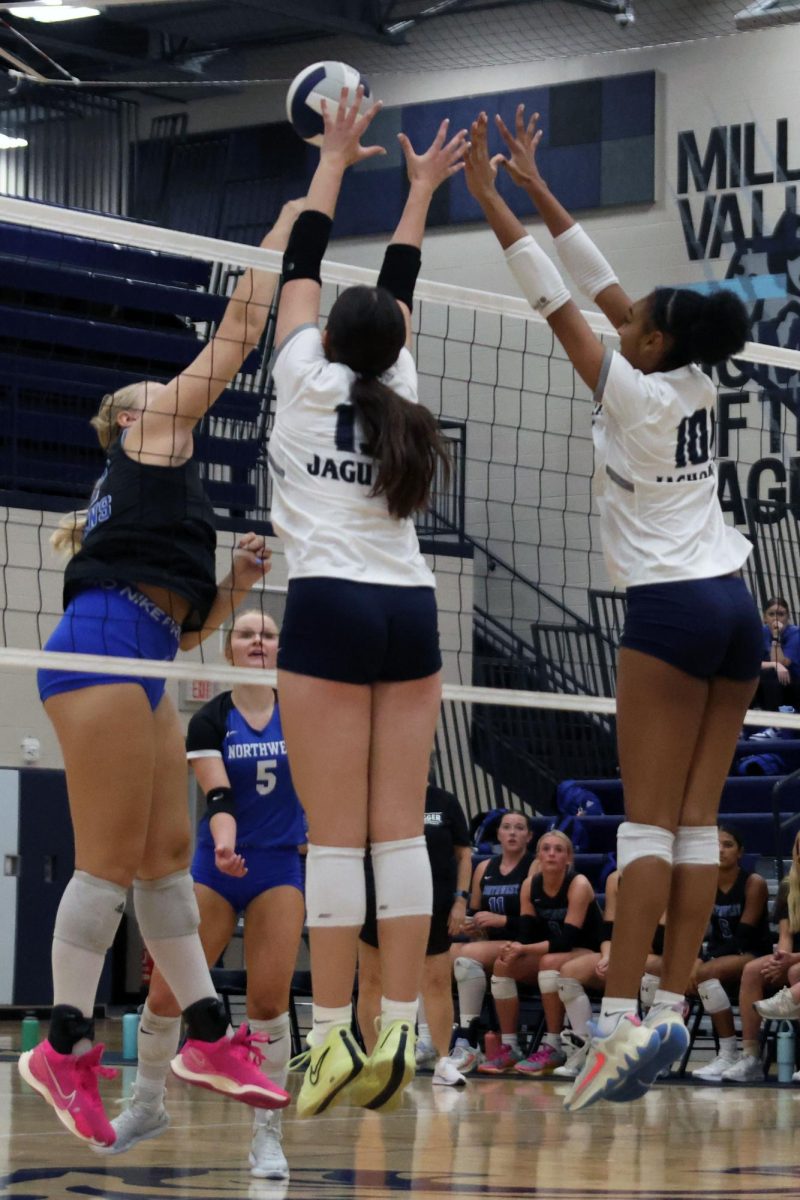 ____ and junior Leilah Perry jump to block the ball.