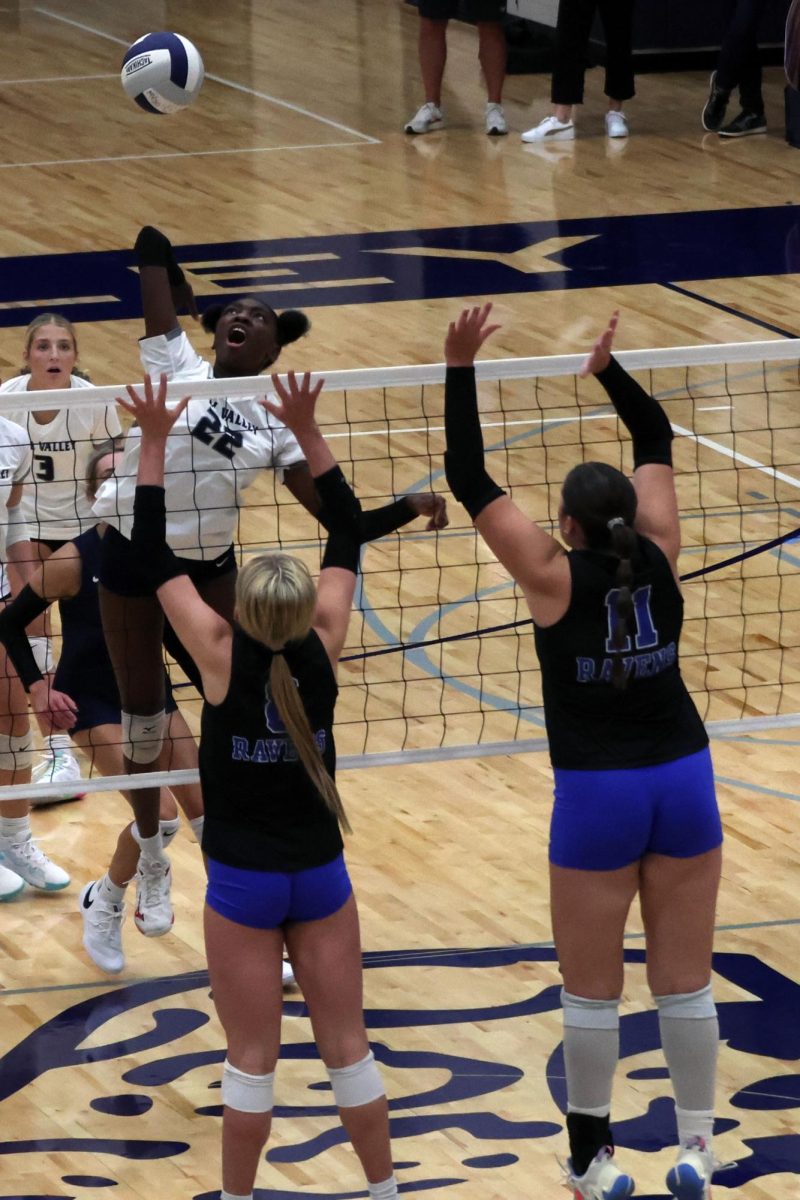 Junior Olivia Nzioki raises her arm as she jumps to spike the ball.