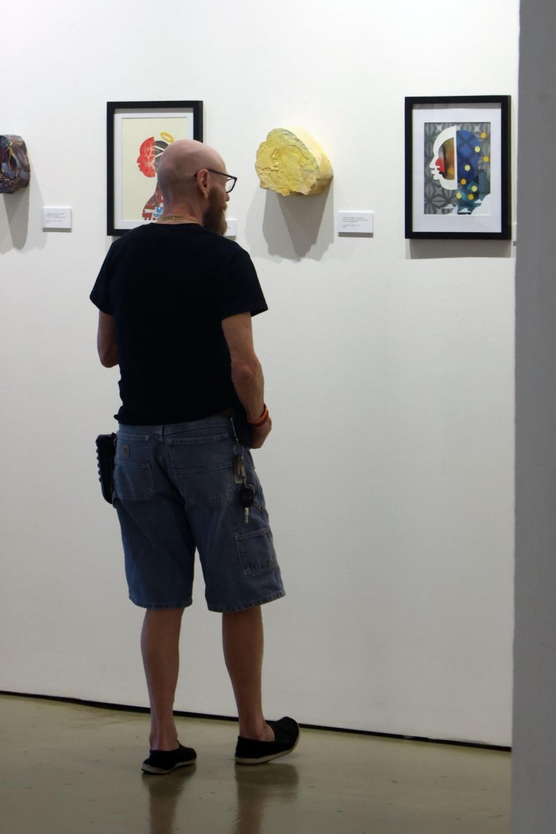 Man observes art in an indoor gallery.