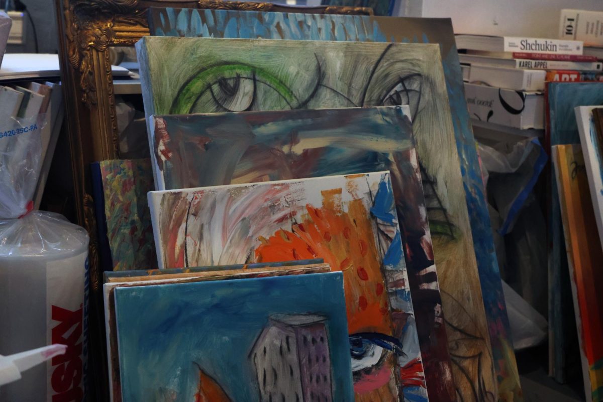 Paintings by artist David Uhlig, who uses the name Davado in his art, fills his area of the shared art studio.