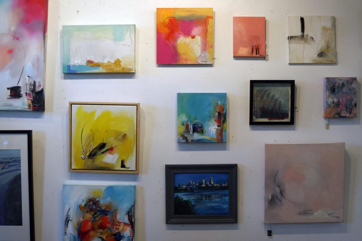 Paintings by Noelle Stoffel are displayed in her section of the studio.