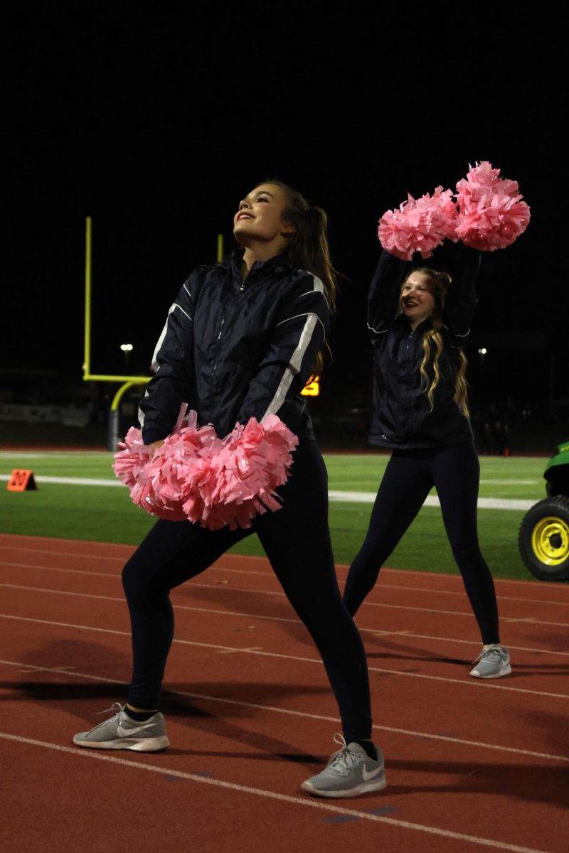 Dancing on beat, senior Josie Benson and sophomore Chloe Thomas shake their pom poms to the song playing. 
