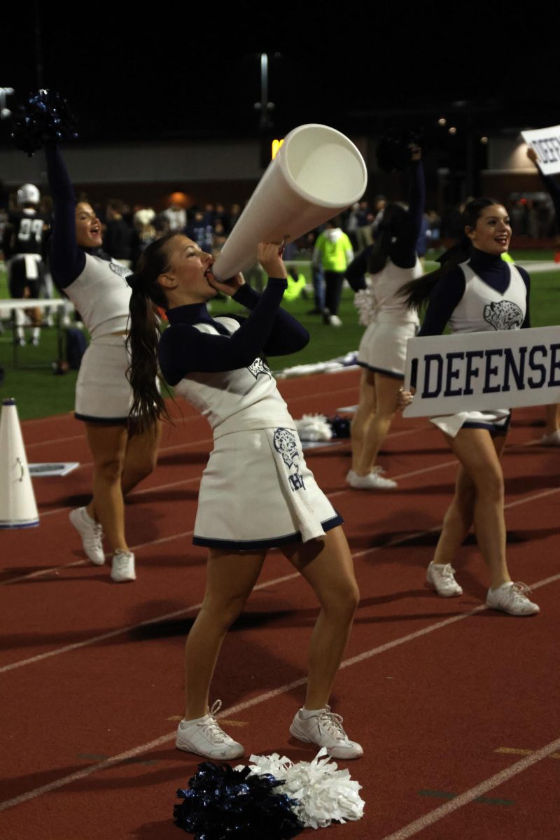 Junior Lillian Verbenec yells into a megaphone to hype up the crowd.
