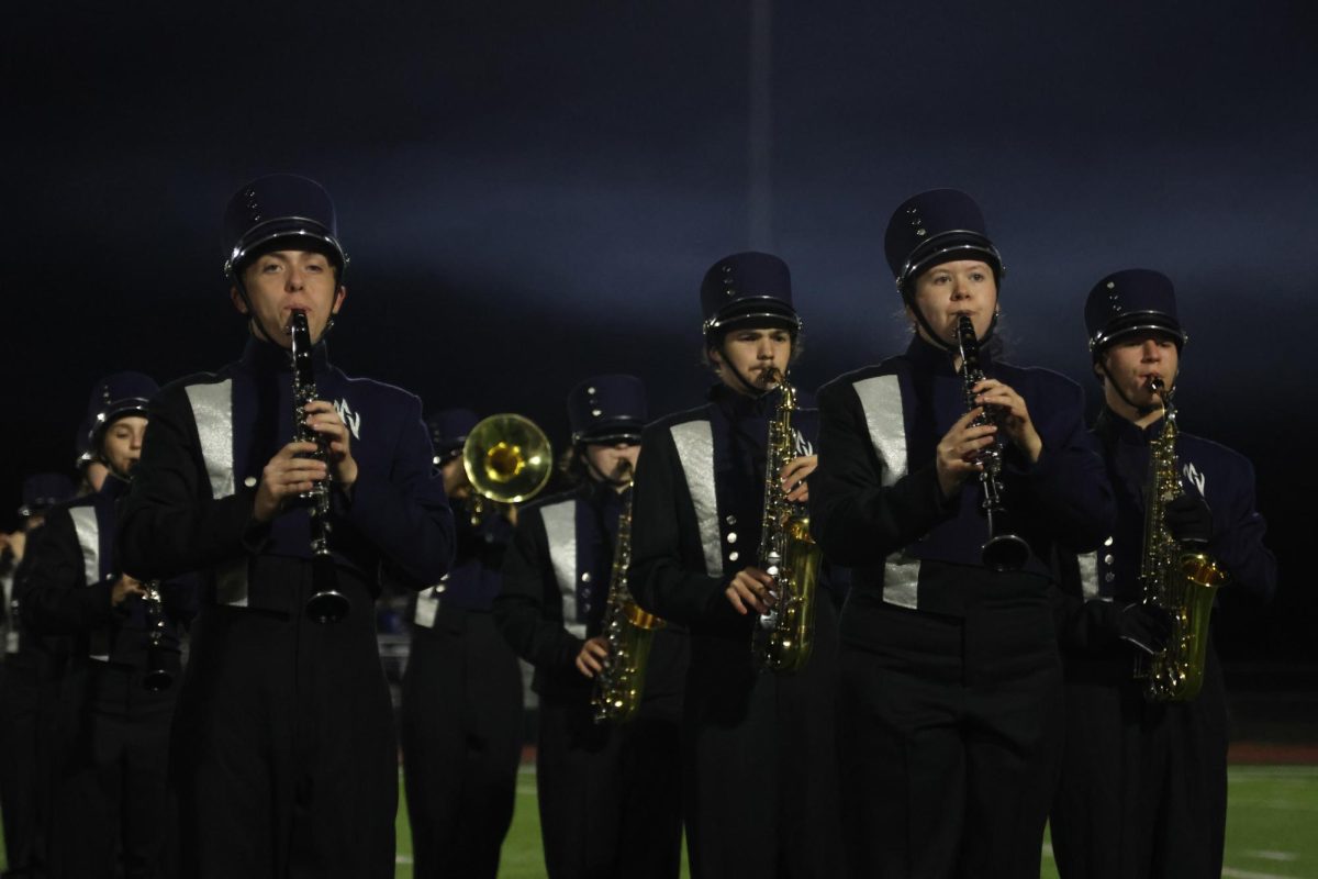 As a ensemble, junior Jamie Boggs and sophomore Blayne Chrisman play in the band halftime show “Seasons Change." 
