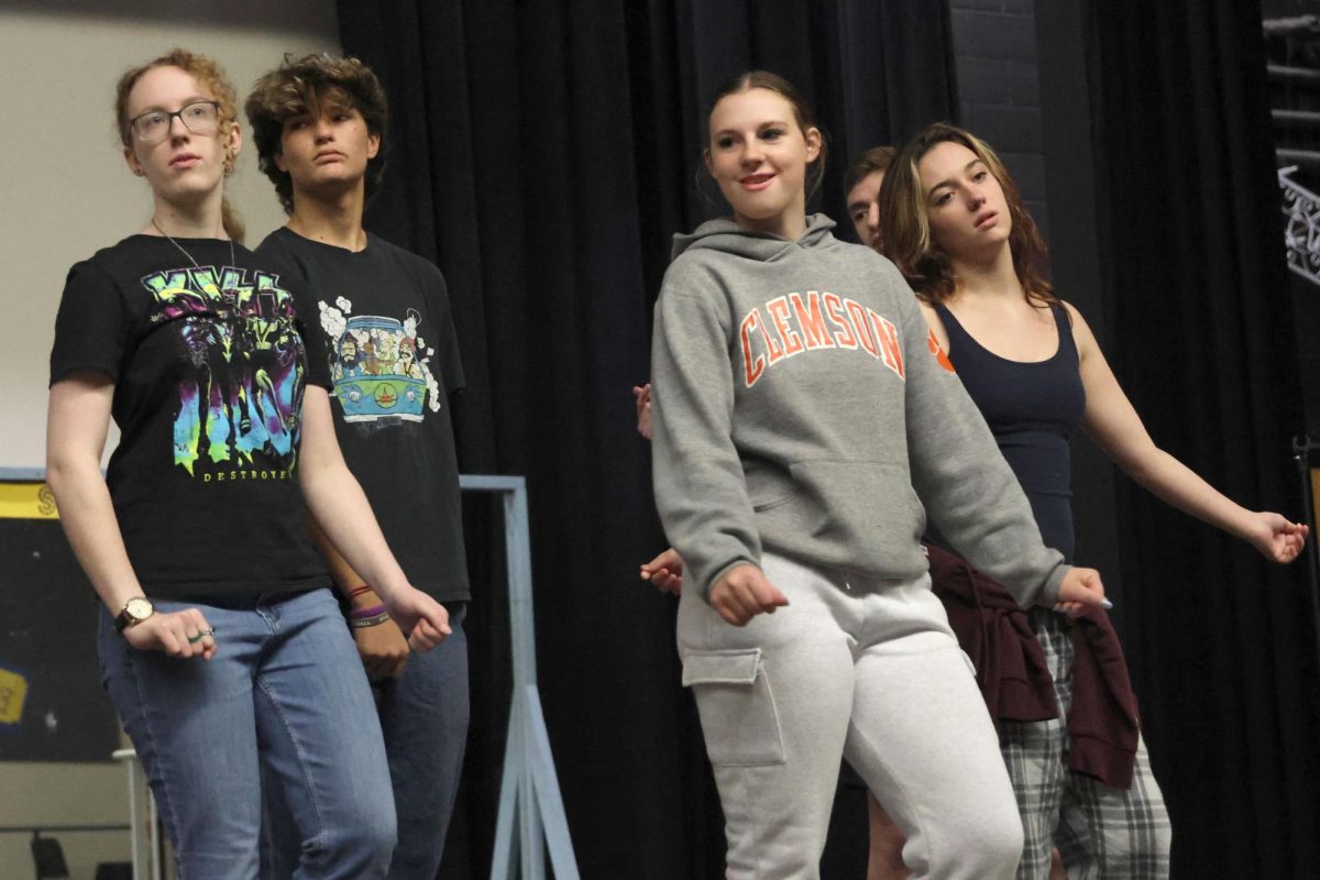 Juniors Madison Davied, Pete Williams, Lilly Gibson, and Katie Davis review the choreography for the opening number. 