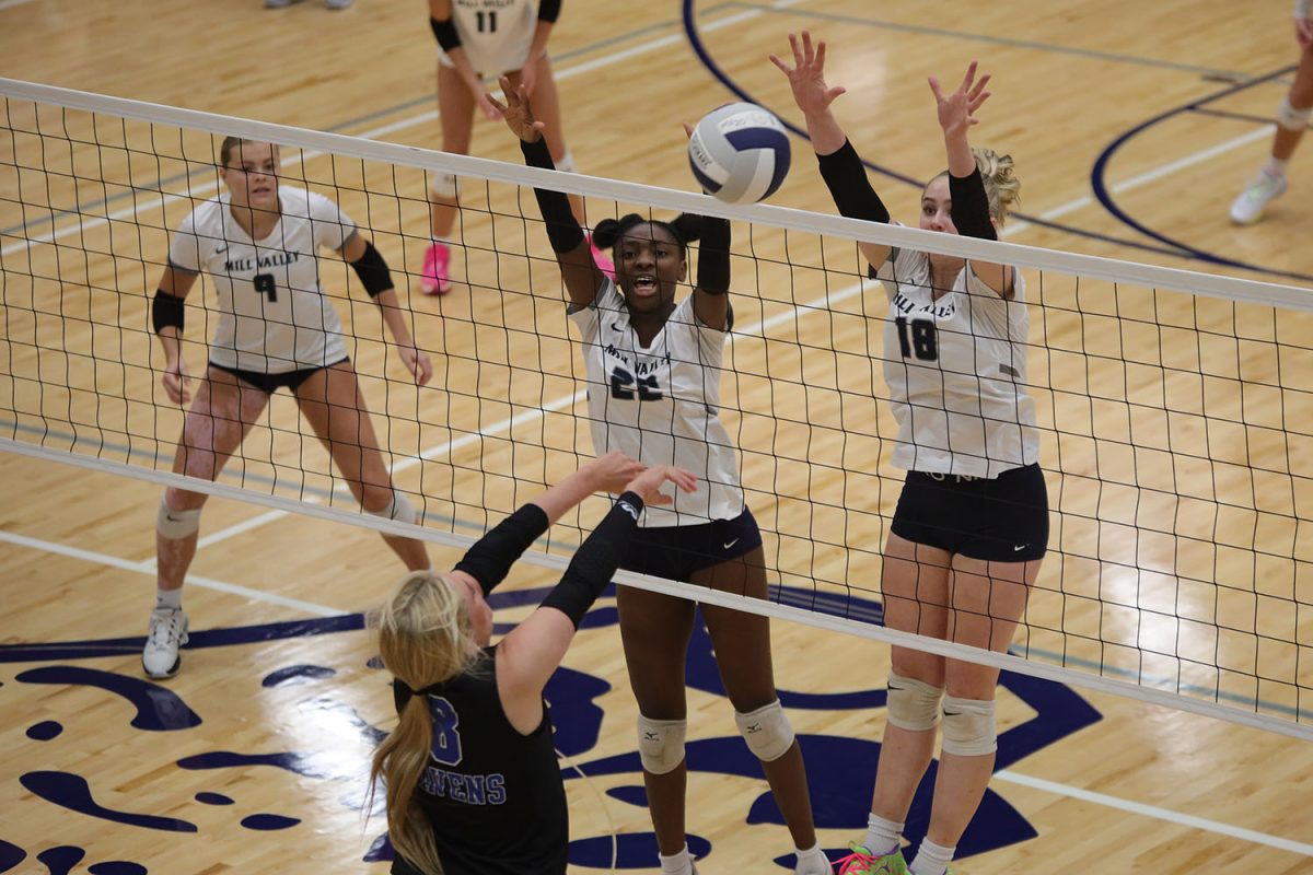 With their arms up, junior Olivia Nzioki and sophomore Riley Riggs block the ball Tuesday, Oct. 1.