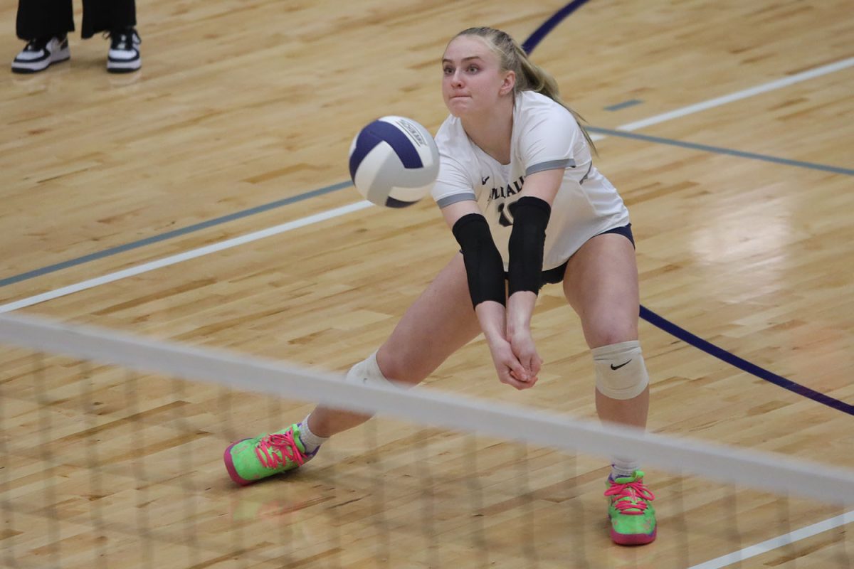 With her arms extended, sophomore Riley Riggs prepares to get a dig Tuesday, Oct. 1. 