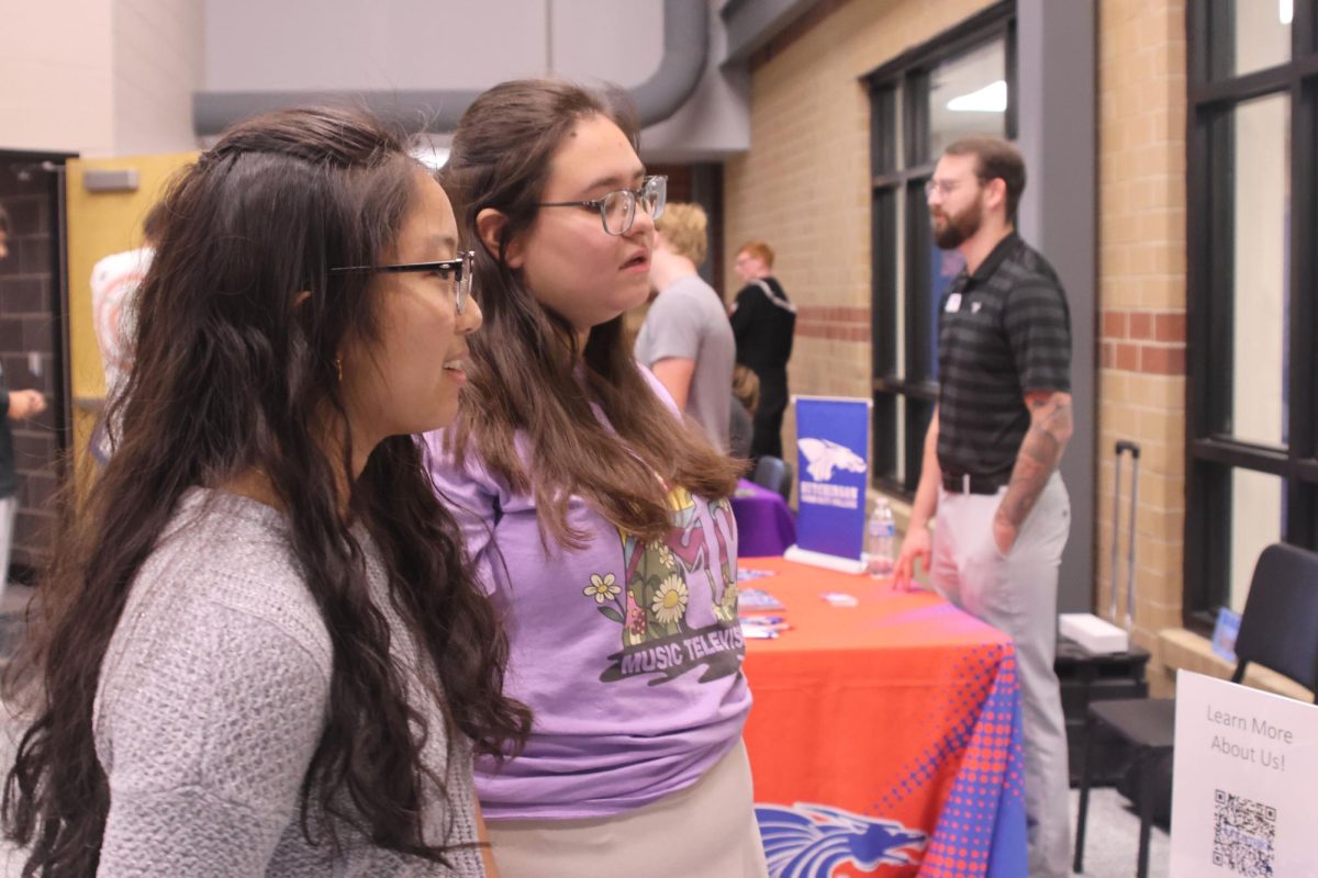 Seniors Alivia Thatlor and Gillian Szymczak talk to the representatives from Huhtamaki.