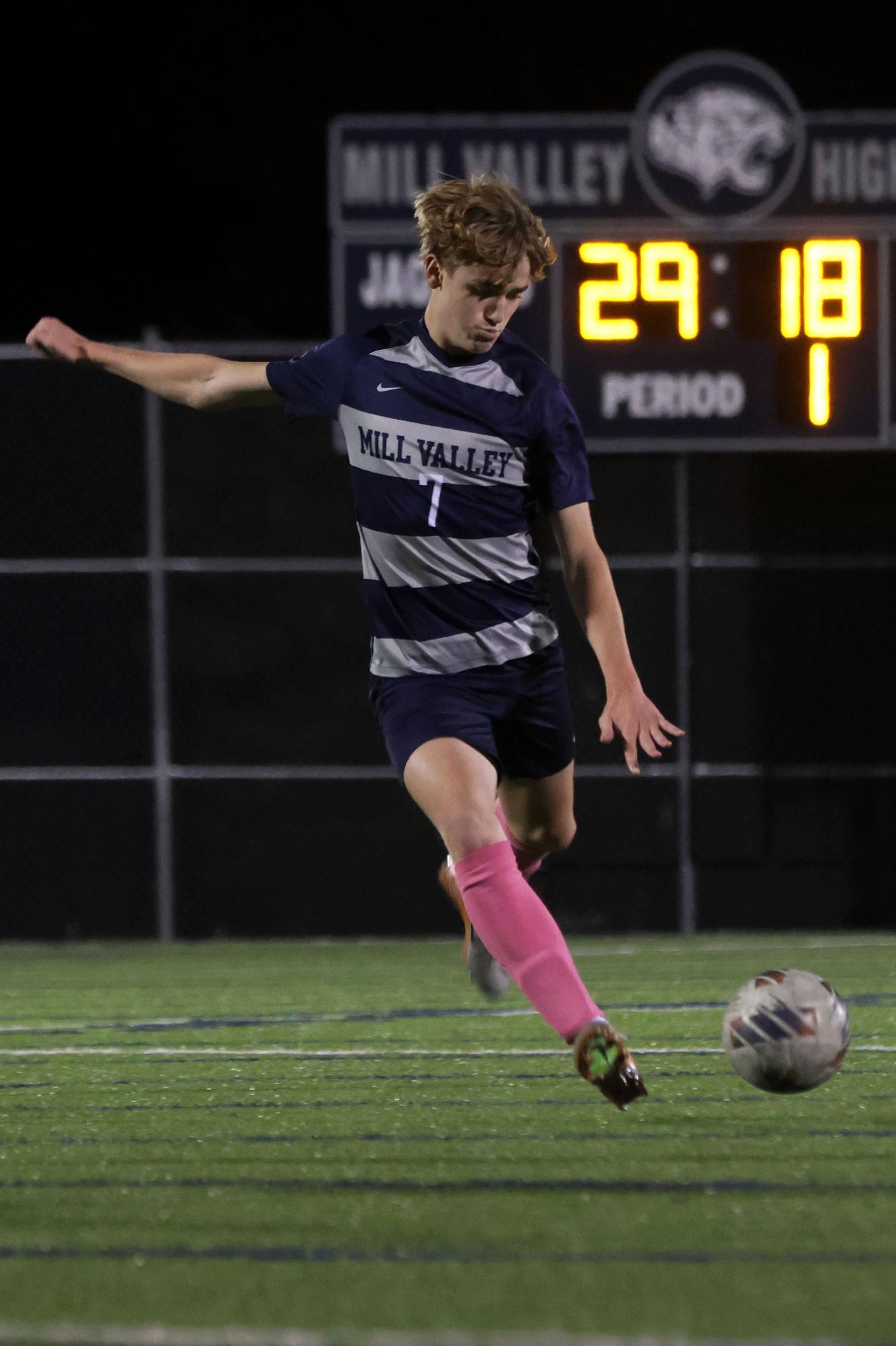 Looking down at the ball, junior Ethan Walter attempts to pass to a teammate.