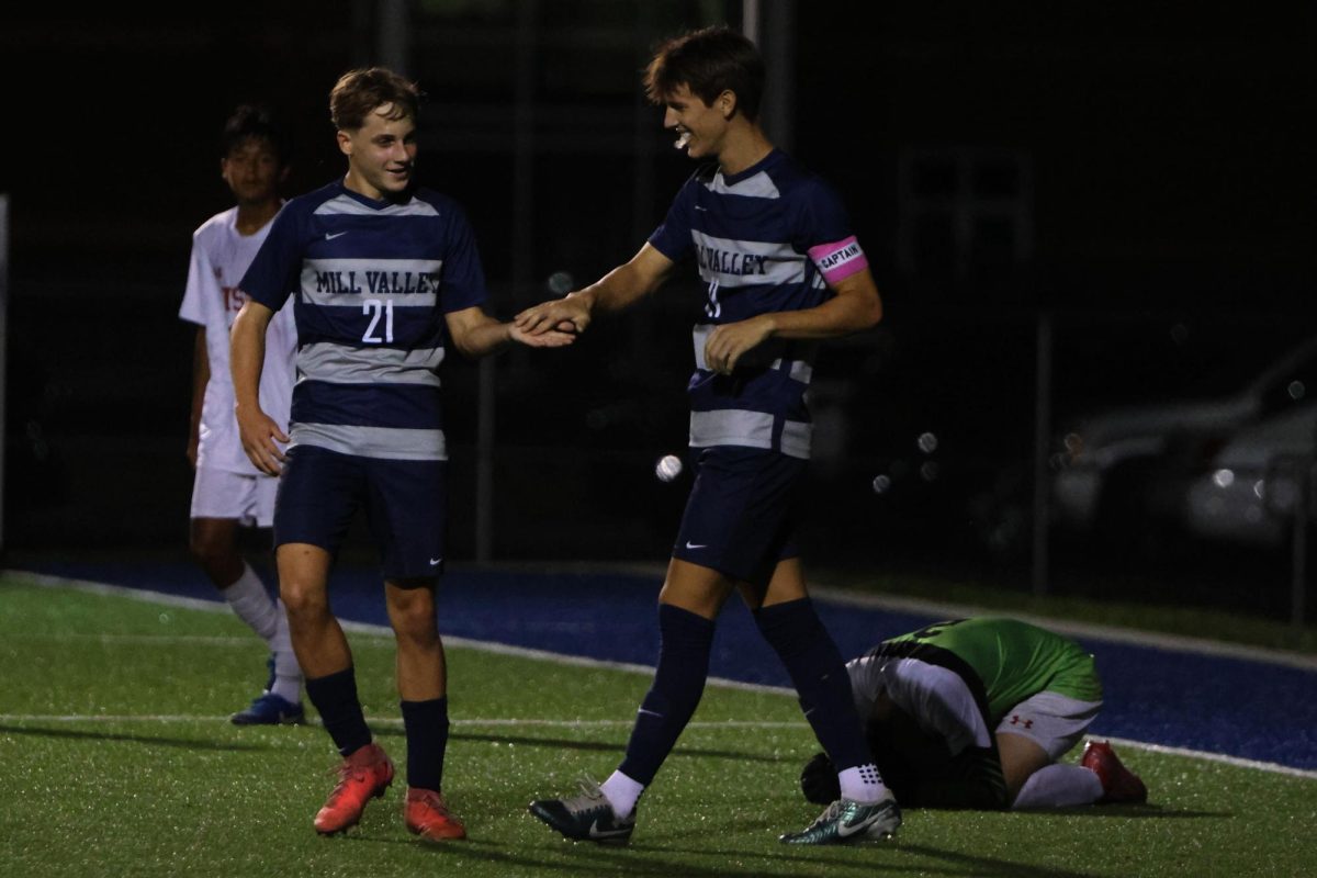 After scoring a goal, freshman Austin Brown high-fives senior Brady Robins as a celebration. 