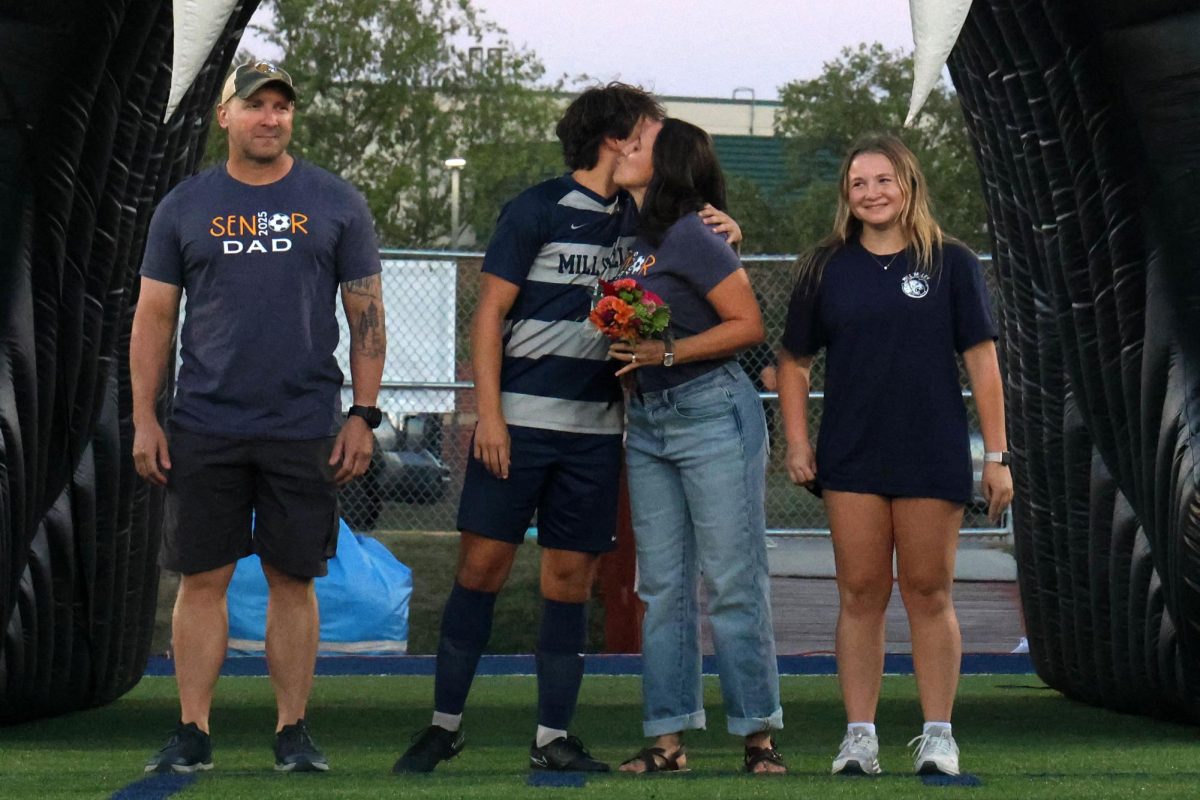 During senior night recognition, senior Kai Burford hugs his mom.