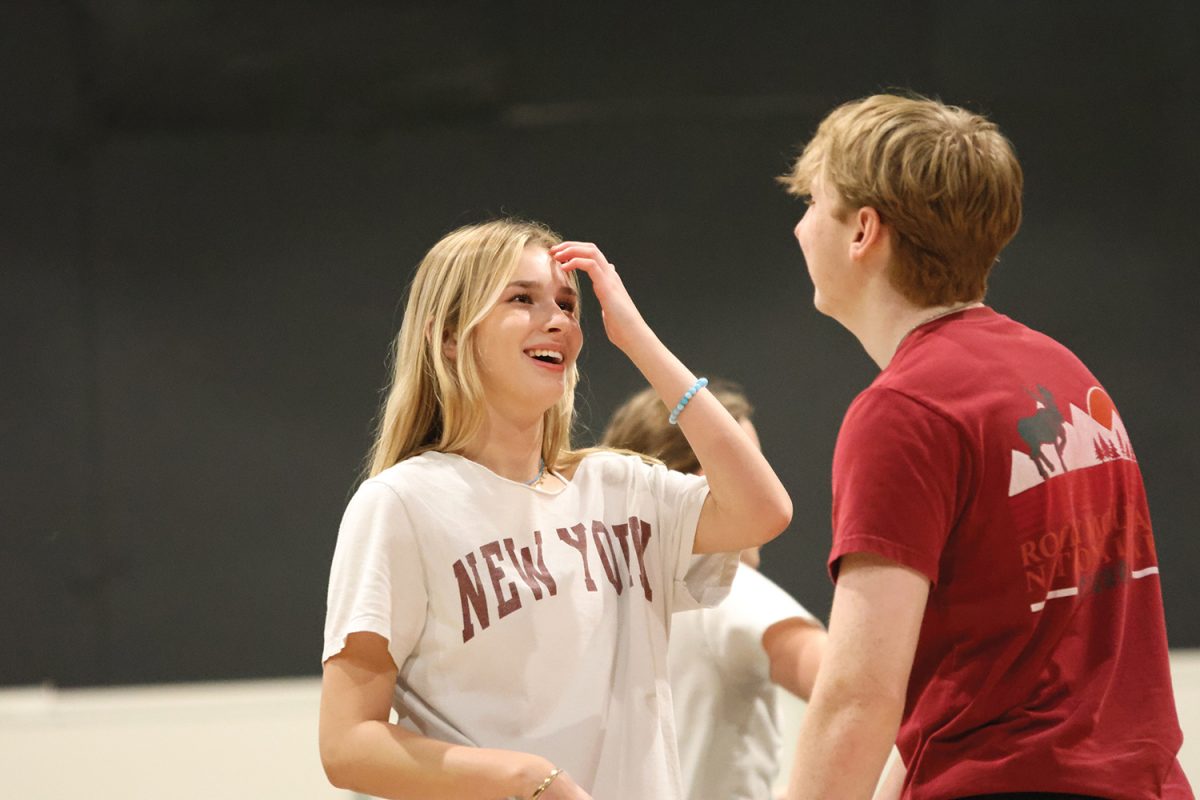 After finishing a run of a song, senior Logan Koester and junior Grace Holland laugh about the dance. 