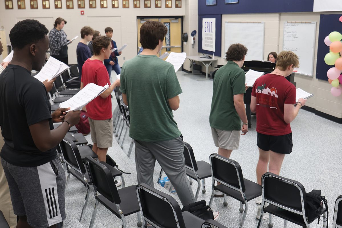 During music rehearsals choir teacher Laura VanLeeuwen teaches the boys cast the opening number.