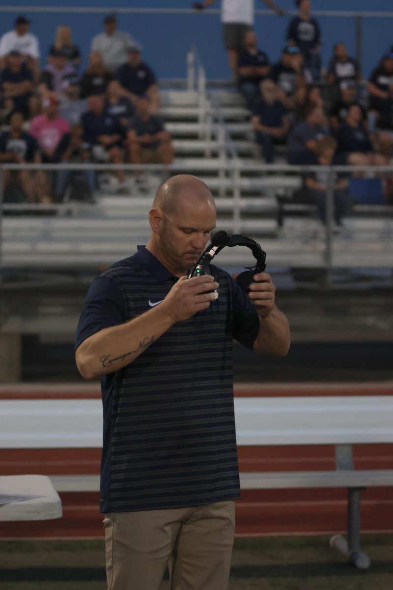 Staying focused, Coach Ress gets ready to put his headset on. 