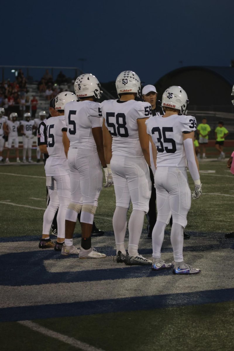 Preparing for the coin toss, seniors Andy Watts, Jayden Woods, Abe Shaffer and Brayden Sword stand together on the field. 