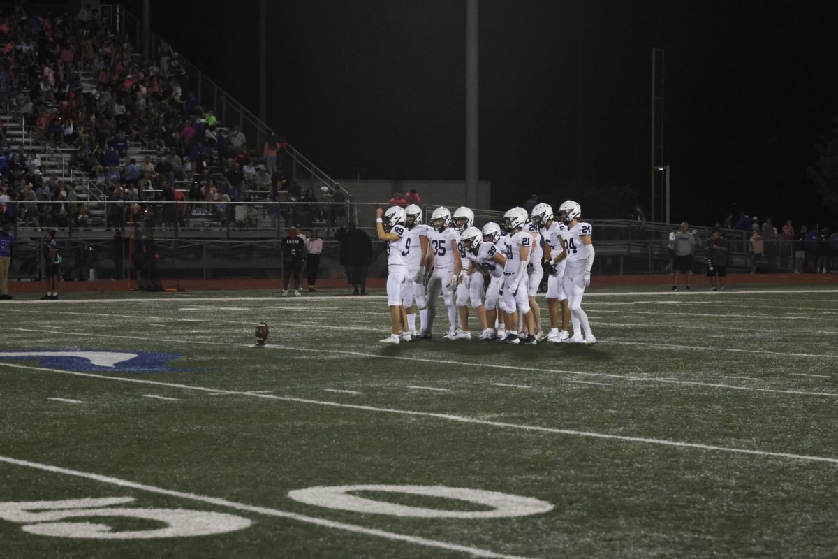 Getting ready to punt the ball, senior Aiden Standley converses with teammates. 