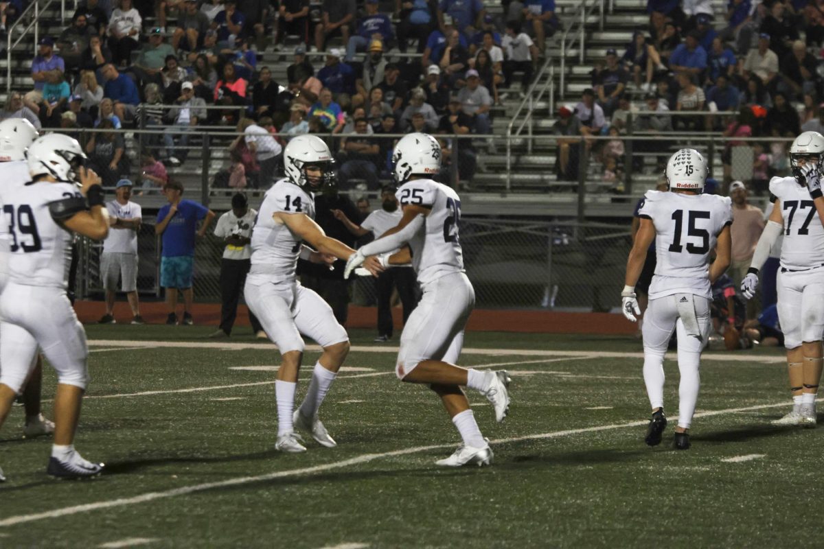 Celebrating a previous play, senior Connor Bohon and junior Reggie Reece embrace with a high five. 