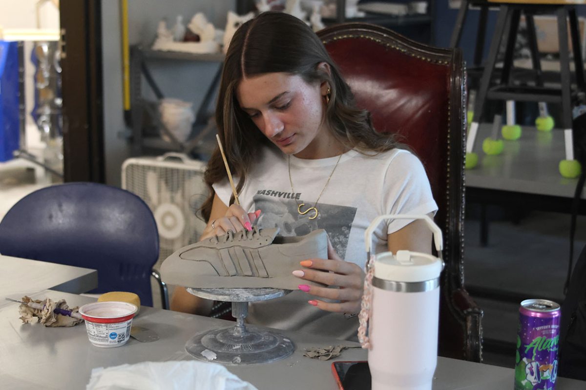 Senior Seville Skinner adds small details to her shoe sculpture as she finishes it.