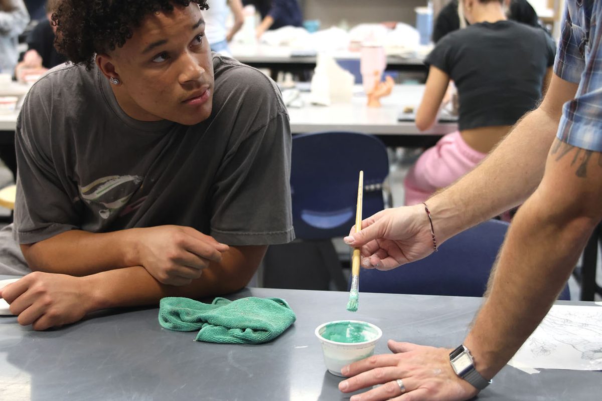 Junior MJ Wash listens to Ceramics teacher Bryan Lloyd as he gives advice on what to do for his project.
