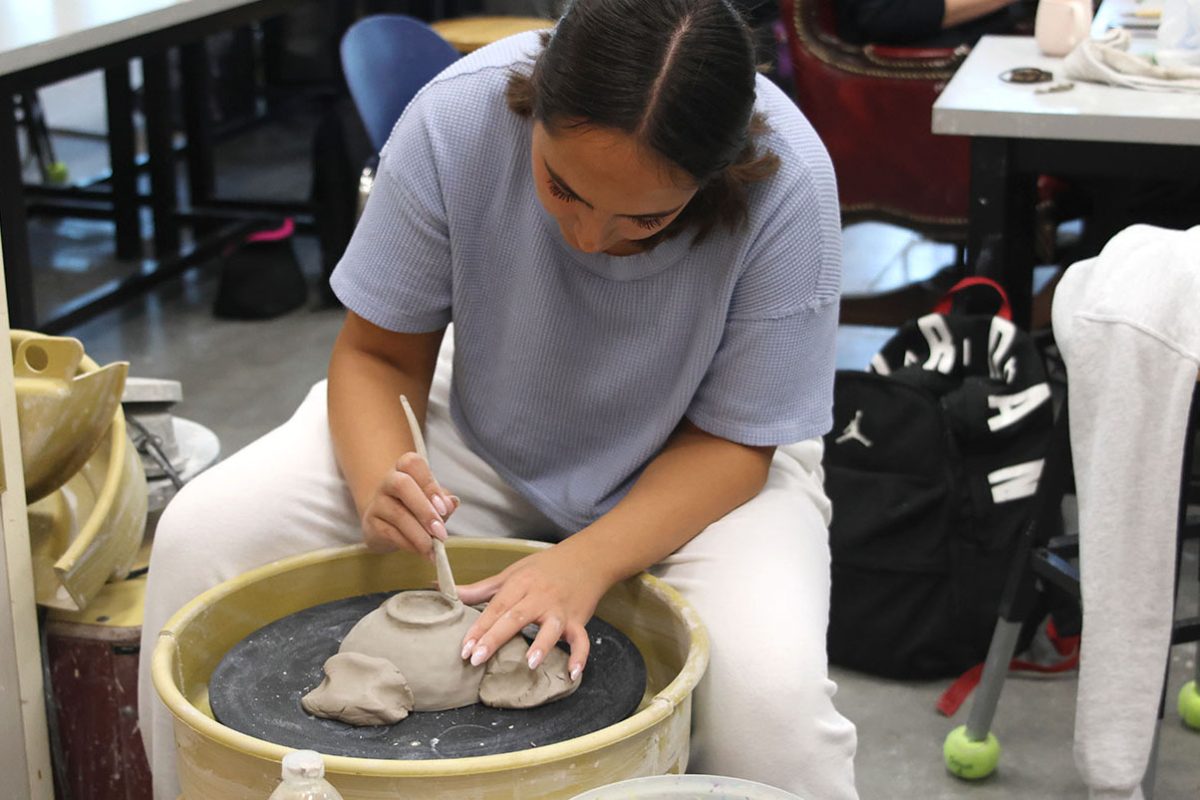 Junior Abbie Kroupa adds what they call a “foot” on the bottom of her bowl as she finishes it.