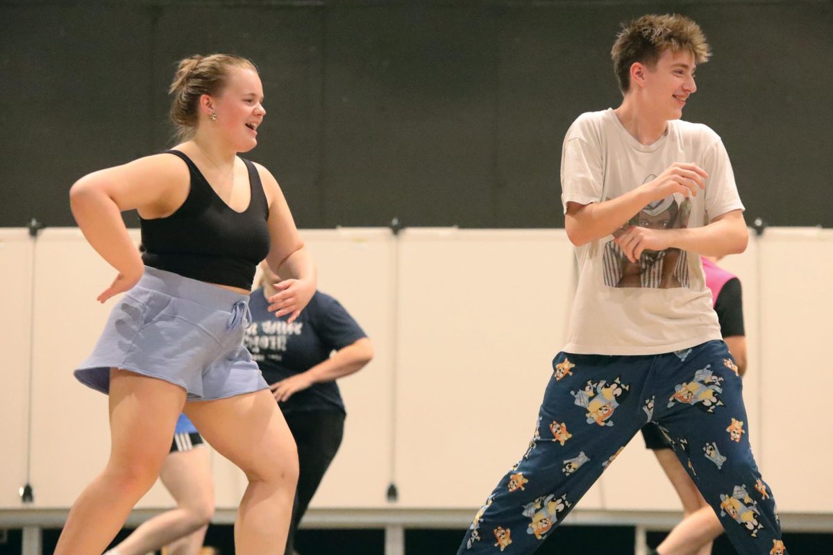 Junior Izzy Simms teaches a dance to the cast of footloose and freshman Jack Musil laughs as he learns it.