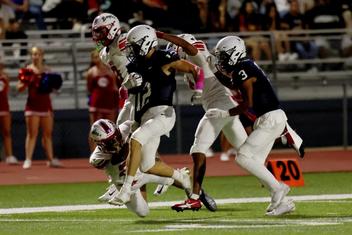 Ball in hand, junior Blake Jay tries to avoid the tackle.
