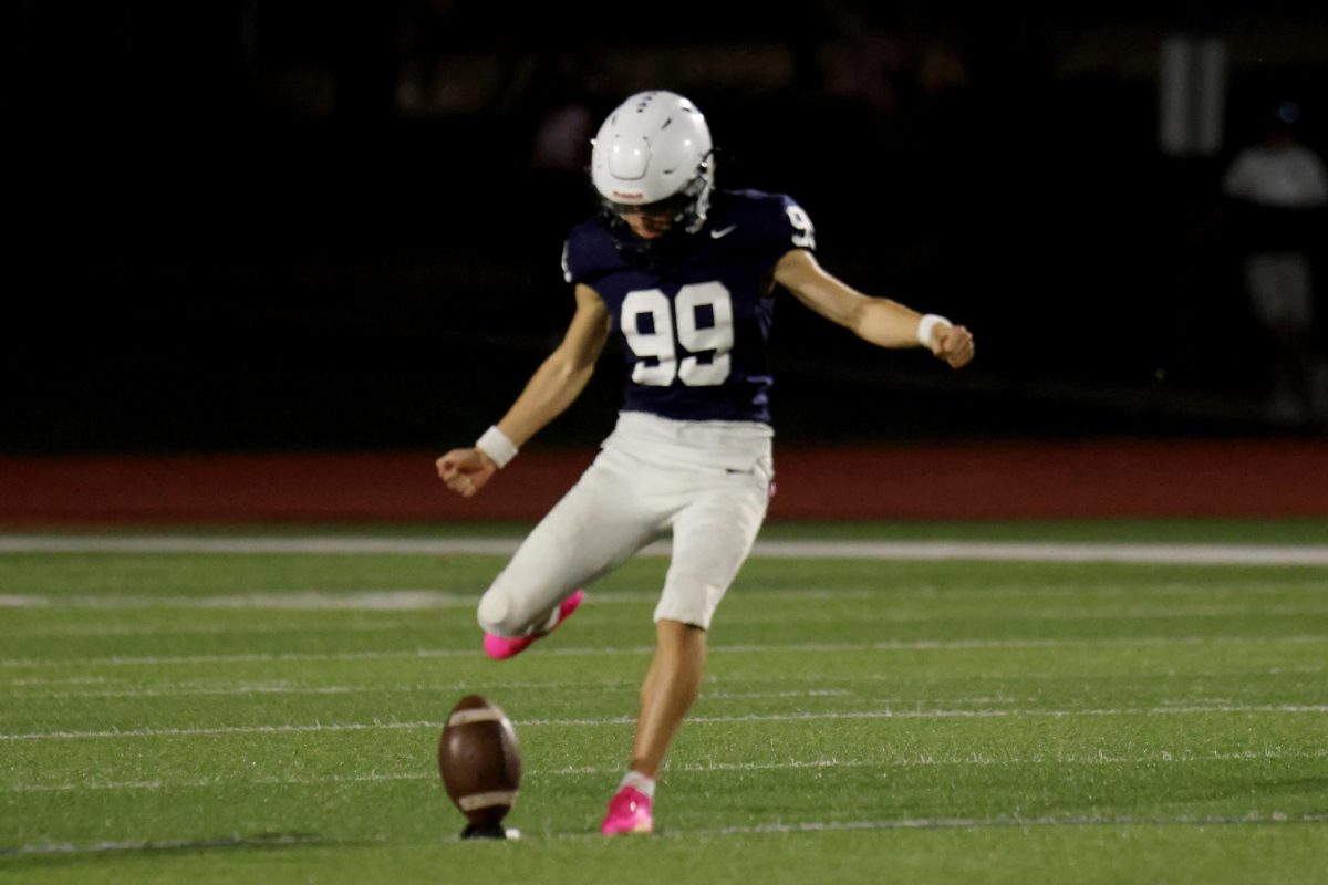 Eyes on the ball, senior Aiden Standley kicks the ball.
