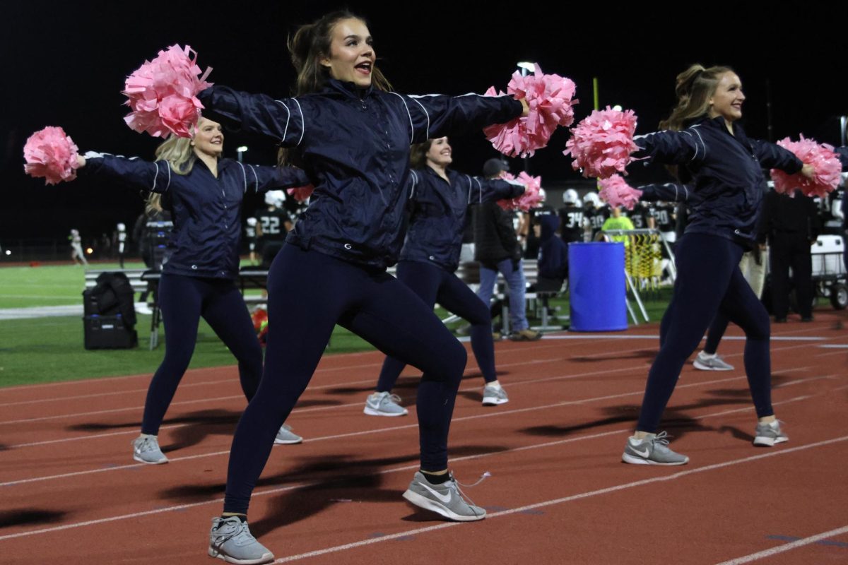 Senior Josie Mason leads the Silver Stars in their sideline routine as people enter the Mill Valley’s football stadium. 