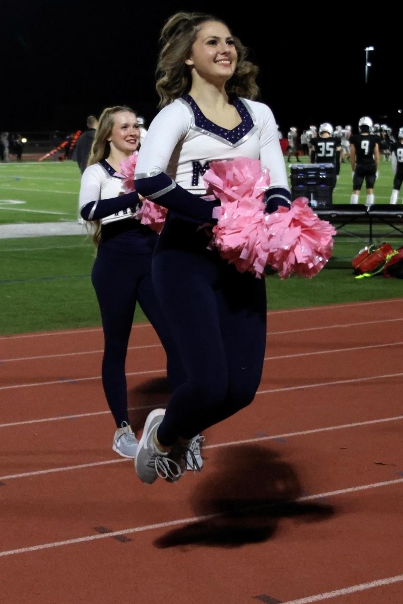 Jumping in the air, junior Addison Maier rallies the crowd before the end of the second half.